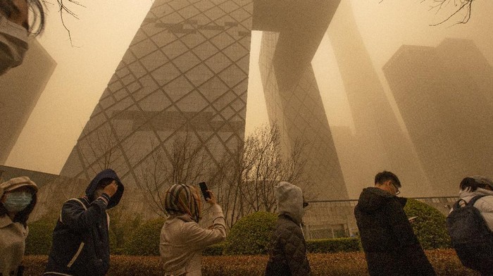 Gegara Badai Pasir, China Diselimuti Kabut Kuning Berbahaya Cars are driven along a street amid a sandstorm during the morning rush hour in Beijing, Monday, March 15, 2021. The sandstorm brought a tinted haze to Beijing's skies and sent air quality indices soaring on Monday. (AP Photo/Mark Schiefelbein)