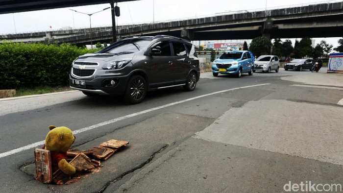 Jalan Ambles di Basuki Rachmat Dipasangi Boneka Jalan Basuki Rachmat, Jakarta timur, Senin (15/03/2021), kondisi aspal ambles dan hanya dipasang boneka serta pecahan genteng untuk menutupinya.