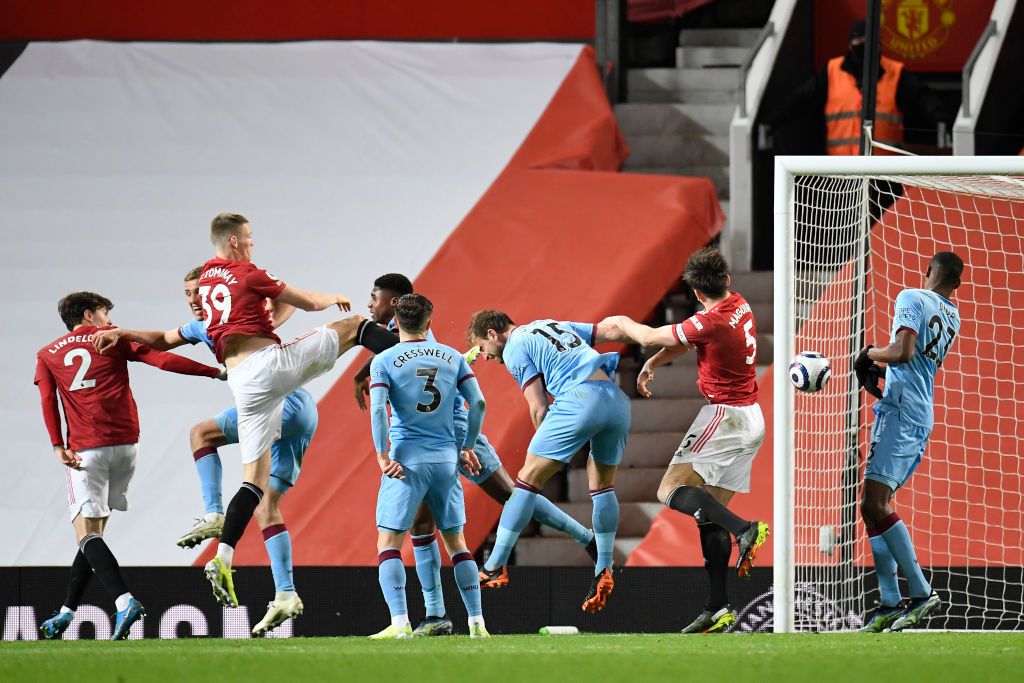 MANCHESTER, ENGLAND - MARCH 14: Craig Dawson of West Ham United scores an own goal for Manchester United's first goal whilst under pressure from Scott McTominay of Manchester United during the Premier League match between Manchester United and West Ham United at Old Trafford on March 14, 2021 in Manchester, England. Sporting stadiums around the UK remain under strict restrictions due to the Coronavirus Pandemic as Government social distancing laws prohibit fans inside venues resulting in games being played behind closed doors. (Photo by Peter Powell - Pool/Getty Images)