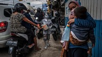 Mereka berjalan dengan menyodorkan kardus untuk meminta uang kepada para pengguna jalan.  