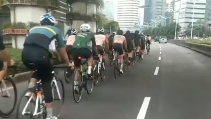 Penampakan pleton pesepeda keluar jalur khusus sepeda.