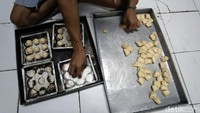 Seorang pekerja membentuk roti sesuai ukuran yang telah ditentukan.
