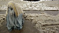 Langkah itu dilakukan hampir dua tahun setelah peristiwa pengeboman hotel dan gereja pada Minggu Paskah pada April 2019 lalu. Seorang wanita Afghanistan yang mengenakan burqa kotor basah duduk di jalan basah bersalju meminta uang saat turun salju pada tanggal 16 Februari 2003 di Kabul, Afghanistan. Paula Bronstein/Getty Images.