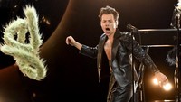 Dengan busana hitam dan aksesori bulu-bulu, Harry Styles seperti menguasai panggung. (Foto: Getty Images via AFP/KEVIN WINTER) 