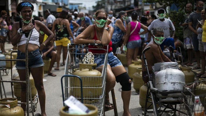 Rows of cooking gas stand in the street where they were placed to keep people's place in line to buy low-cost fuel from the Petrobrás Oil Tankers Union in the Vila Vintem favela of Rio de Janeiro, Brazil, Friday, March 12, 2021. The event was part of a solidarity campaign marking The National Day of Struggles in Defense of State-owned Companies. (AP Photo/Bruna Prado)