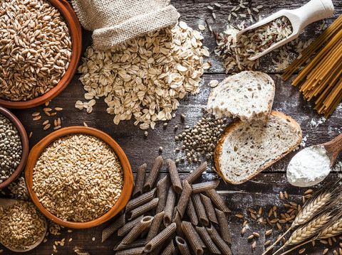Top view of wholegrain and cereal composition shot on rustic wooden table. This type of food is rich of fiber and is ideal for dieting. The composition includes wholegrain sliced bread, various kinds of wholegrain pasta, wholegrain crackers, grissini, oat flakes, brown rice, spelt and flax seeds. Predominant color is brown. DSRL studio photo taken with Canon EOS 5D Mk II and Canon EF 100mm f/2.8L Macro IS USM