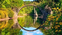 Jembatan ini bernama The Devils Bridge atau bahasa lokal menyebutnya Rakotzbrucke. Konon desas-desus warga lokal mengatakan jembatan ini dulunya dibangun oleh setan.