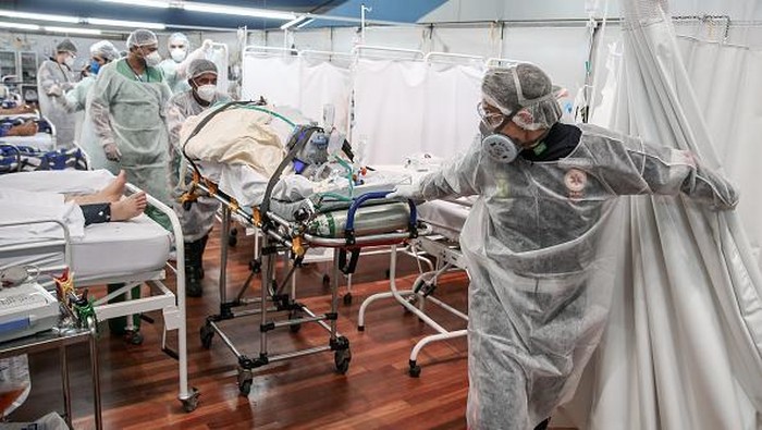 Melihat Sibuknya Nakes di RS Darurat Corona Brasil SANTO ANDRE, BRAZIL - MARCH 11: Medical staff members transport a patient on a stretcher at the Pedro DellAntonia Sports Complex field hospital as coronavirus cases soar on March 11, 2021 in Santo Andre, Brazil. The state of Sao Paulo has reached over 80% occupancy in intensive care units and has declared a red alert as the spread of COVID-19 has accelerated in Brazil in recent weeks. State Health Minister Jean Gorinchteyn announced that they are already recruiting health professionals for reinforcement and working in 140 extra ICUs to prevent the collapse of the health system. 38 patients with COVID-19 have already died on the waiting list for ICUs beds in the state in the first ten days of March. (Photo by Alexandre Schneider/Getty Images)