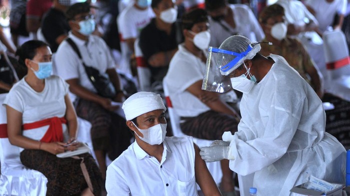 Presiden Joko Widodo (kedua kiri) didampingi Menteri Kesehatan Budi Gunadi Sadikin (ketiga kiri), Gubernur Bali Wayan Koster (keempat kiri) dan Wagub Bali Tjokorda Oka Artha Ardana Sukawati (kiri) meninjau proses vaksinasi COVID-19 di Puri Ubud, Gianyar, Bali, Selasa (16/3/2021). Kunjungan tersebut dilakukan Presiden Jokowi untuk melihat secara langsung proses vaksinasi secara massal kepada para pelayan publik, tokoh agama dan adat serta masyarakat setempat. ANTARA FOTO/Fikri Yusuf/rwa.