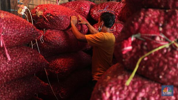 Pekerja menurunkan bawang merah yang baru tiba dari Brebes, Jawa Tengah di Pasar Kramat Jati, Jakarta, Rabu (17/3/2021).  Menurut pedagang setempat harga bawang merah di Jakarta naik dari harga 17 ribu menjadi 28 ribu per kilo gram karena meningkatnya permintaan dan sedikitnya stok bawang merah pada musim penghujan. Pantauan CNBC Indonesia permintaan bawang merah mulai sepi peminat, dari kios Los H bawang merah masih banyak stok. (CNBC Indonesia/ Tri Susilo)