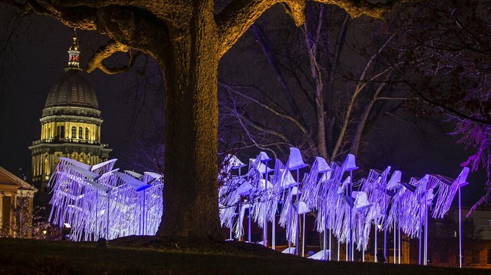 Instalasi Pita Ungu untuk Korban COVID-19 di Illinois Sebuah instalasi dari pita berhiaskan lampu dengan warna dominan ungu menjeng di depan kantor Gubernur Illinois JB Pritzker, ada apa?