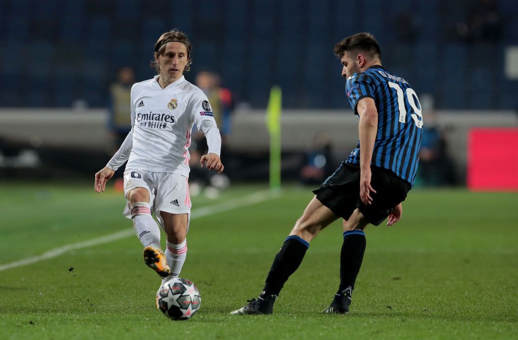 BERGAMO, ITALY - FEBRUARY 24: Luka Modric of Real Madrid makes a pass whilst under pressure from Berat Djimsiti of Atalanta B.C. during the UEFA Champions League Round of 16 match between Atalanta and Real Madrid at Gewiss Stadium on February 24, 2021 in Bergamo, Italy. Sporting stadiums around Italy remain under strict restrictions due to the Coronavirus Pandemic as Government social distancing laws prohibit fans inside venues resulting in games being played behind closed doors. (Photo by Emilio Andreoli/Getty Images)