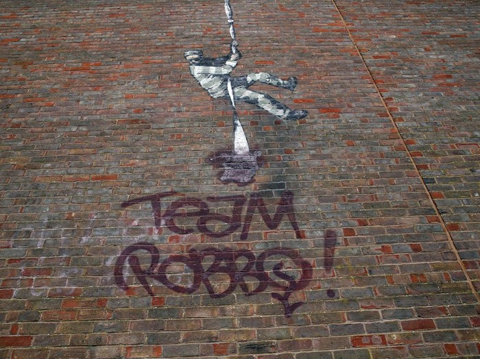 Artwork in reading. The Banksy artwork which was painted on the side of the former prison in Reading has now been defaced. Picture date: Tuesday March 16, 2021. Reading Prison is renowned as the location where the playwright Oscar Wilde served two years hard labour for gross indecency. Although the site closed to prisoners in 2013, its future is currently the focus of fierce debate. Photo credit should read: Steve Parsons/PA Wire URN:58638601 (Press Association via AP Images)
