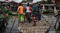 Ojek perahu itu membantu menyeberangkan warga setempat untuk menghindari banjir rob yang selalu datang setiap hari.