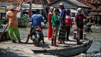 Sejumlah warga menyeberangi banjir rob menggunakan ojek perahu.