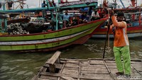 Ojek berahu itu melintas di antara perahu nelayan Desa Morodemak, Demak.
