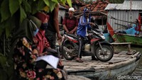 Ojek perahu melintasi banjir rob di Desa Morodemak, Bonang, Demak, Jawa Tengah.