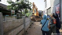 Ada 2 ekskavator yang diturunkan. Ekskavator ini digerakkan pekerja untuk merobohkan tembok yang menghalangi rumah Hadiyanti.
