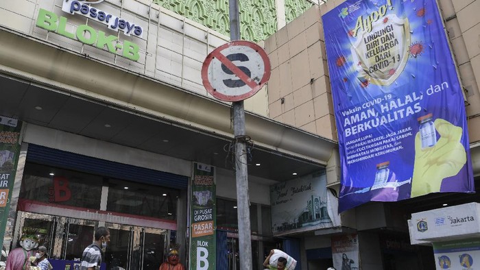 Spanduk sosialisasi vaksinasi COVID-19 terpasang di area luar blok B Pasar Tanah Abang, Jakarta.