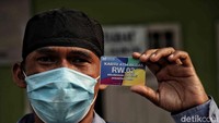 Warga menunjukan kartu ATM beras.