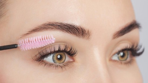 Beautiful Woman with long eyelashes in a beauty salon. Eyelash extension procedure. Cosmetology skin care