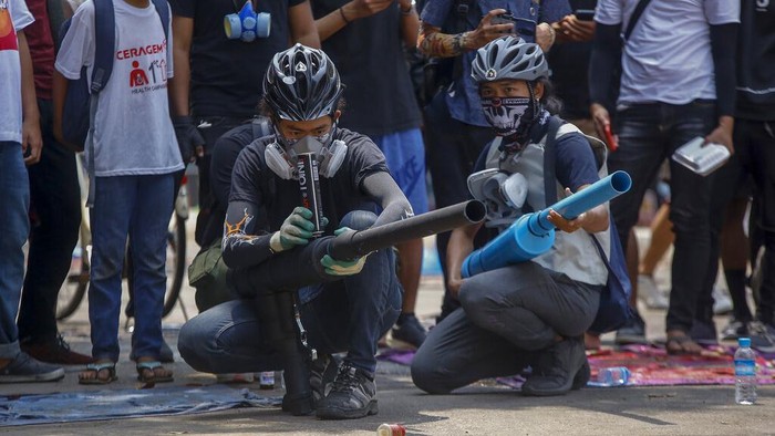 Anti-coup protesters test an improvised weapon they have made to fight with armed Myanmar security forces in Yangon, Myanmar Wednesday, March 17, 2021. (AP Photo)
