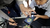 Seorang peserta tengah mencoba memotret produk dengan menggunakan ponsel saat mengikuti pelatihan fotografi di Kampung Bali, Jakarta.