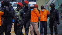 Ke-22 tersangka teroris itu terlihat memakai baju tahanan berwarna oranye. Mereka turun dari pesawat satu per satu dengan menggunakan penutup kepala, kaki, serta tangan yang diborgol.