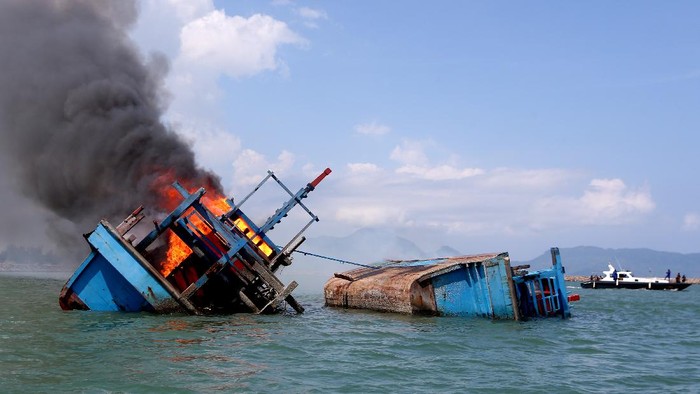 Petugas mengawasi jalannya eksekusi pemusnahan kapal penangkap ikan negara asing berbendera Malaysia di perairan Pelabuhan Samudera Lampulo, Banda Aceh, Aceh, Kamis (18/3/2021). Kejaksaan Negeri Banda Aceh memusnahkan barang bukti tindak pidana perikanan yang telah diputuskan oleh Pengadilan Negeri Banda Aceh berupa dua unit kapal ikan negara asing beserta alat tangkapnya. ANTARA FOTO/Irwansyah Putra/wsj.