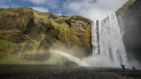 Pelangi terlihat di dekat air terjun Skogafoss, Skogar, di Islandia. Getty Images/Maja Hitij