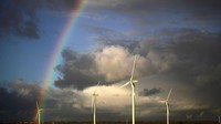 Pelangi muncul di belakang turbin angin di Ince Salt Marshes di Runcorn, Inggris. Getty Images/Christopher Furlong