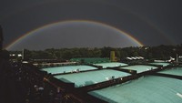Pelangi ganda muncul di atas lapangan tertutup di Klub Tenis Wimbledon, London, Inggris. Getty Images/Mike Hewitt