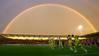 Pemain Tottenham Hotspur dan Doncaster Rovers berlari ke lapangan yang dihiasi busur pelangi di Doncaster, Inggris. Getty Images/Alex Livesey