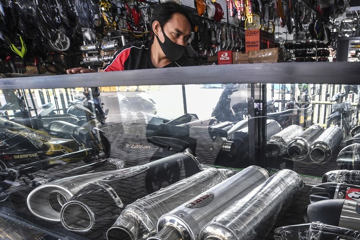 Penjual knalpot dan aksesori modifikasi sepeda motor melayani calon pembeli di kawasan Kampung Melayu, Jakarta, Jumat (19/3/2021). Maraknya razia knalpot racing atau bising oleh pihak kepolisian berdampak pada turunnya penjualan knalpot aftermarket (suku cadang pengganti yang dibuat oleh perusahaan selain produsen asli kendaraan) yang memiliki suara bising. ANTARA FOTO/Muhammad Adimaja/foc.