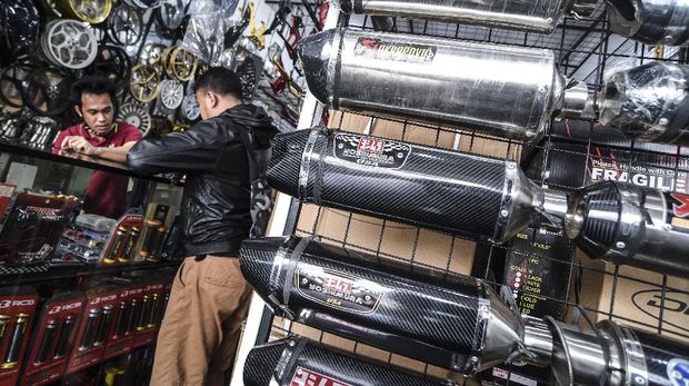 Penjual knalpot dan aksesori modifikasi sepeda motor melayani calon pembeli di kawasan Kampung Melayu, Jakarta, Jumat (19/3/2021). Maraknya razia knalpot racing atau bising oleh pihak kepolisian berdampak pada turunnya penjualan knalpot aftermarket (suku cadang pengganti yang dibuat oleh perusahaan selain produsen asli kendaraan) yang memiliki suara bising. ANTARA FOTO/Muhammad Adimaja/foc.