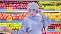 Belanja ke supermarket, Herlin Kenza menyempatkan untuk berpose di depan rak buah-buahan Ada apel, pir, dan lemon di sana. Foto: Instagram @herlinkenza