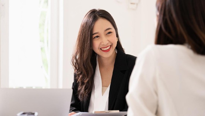 A young attractive asian woman is interviewing for a job. Her interviewers are diverse. Human resources manager conducting job interview with applicants in office