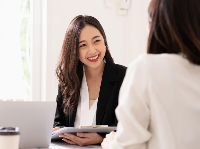 A young attractive asian woman is interviewing for a job. Her interviewers are diverse. Human resources manager conducting job interview with applicants in office