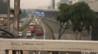 Ada coretan Hati-hati jembatan angker di salah satu sudut JPO. 