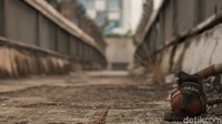 Ada sampah makanan, minuman kopi, sampai sepatu berserakan begitu saja di atas JPO.
