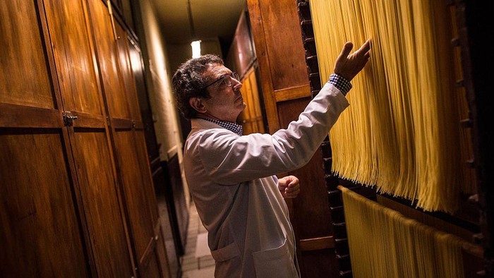 Melihat Pabrik Pasta Tertua di Spanyol CALDES DE MONTBUI, SPAIN - OCTOBER 27: An employee cuts noodles at Pasta Sanmarti's factory on October 27, 2015 in Caldes de Montbui, Spain. The Sanmarti family has been involved in the production of pasta since 1700. Carles Sanmarti, the 8th generation descendent, still uses the original recipe using just amber durum wheat semolina, thermal mineral water and egg free. Sanmarti nowadays exports their pasta products to countries as diverse as the United States, China, Denmark and also to the United Kingdom, their largest foreign market. (Photo by David Ramos/Getty Images)