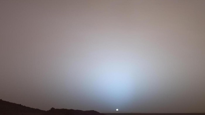 Pada tanggal 19 Mei 2005, Mars Exploration Rover Spirit milik NASA menangkap pemandangan yang menakjubkan ini saat Matahari tenggelam di bawah tepi kawah Gusev di Mars. Mosaik Panoramic Camera (Pancam)