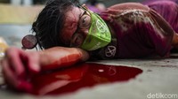 Aksi banjir darah itu sekaligus menuntut Presiden Jokowi untuk mendeklarasikan darurat iklim.