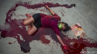 Dalam aksinya para aktivis menggunakan cairan berwarna merah untuk menggambarkan darurat iklim yang semakin parah masa depan banjir darah.
