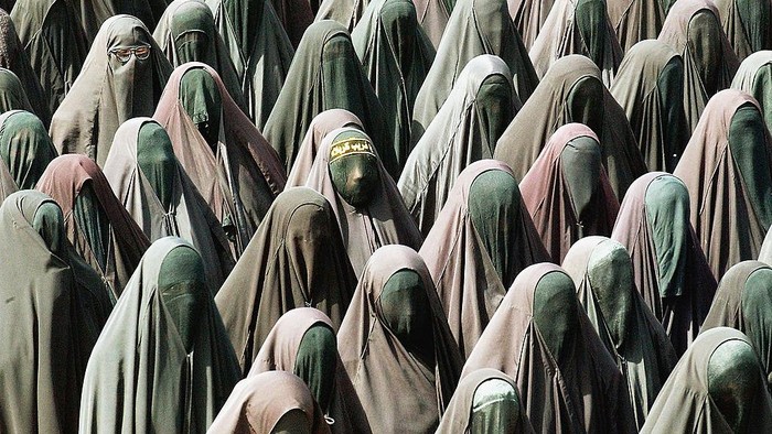 BAGHDAD, IRAQ - APRIL 03:  Female members of the al-Mehdi Army march in Military formation during a military parade through the streets of the Sadr City neighborhood in East Baghdad, on April 03, 2004 in Baghdad Iraq. The Al-Mehdi Army is a Shia militia aligned with the controversial Shia cleric Moqtada Sadr. The parade was meant to be a show of force in tandem with Sadr supporters continued protest against the occupation of Iraq by the U.S. lead coalition forces.
