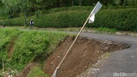 Jalan di samping tebing yang longsor di kawasan Megamendung. Rute Ciawi menuju Megamendung hingga Taman Safari dipilih untuk menghindari jalan raya Puncak yang ramai oleh kendaraan umum.