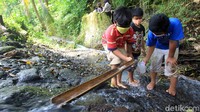 Para siswa tampak serius meneliti sumber mata air.