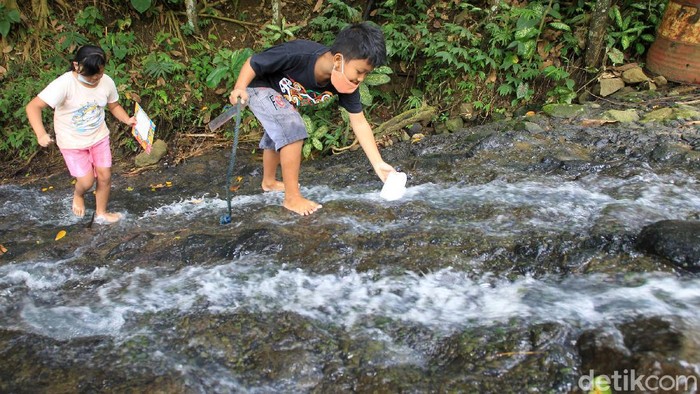 Sejumlah siswa/i SD Kanisius Kenalan berjalan menyusuri hutan dan aliran sungai saat melaksanakan program pembelajaran luar ruangan dengan nama Tilik Belik di kawasan pegunungan Menoreh, Duren Sawit, Kulonprogo, Yogyakarta, Sabtu (20/3/2021).