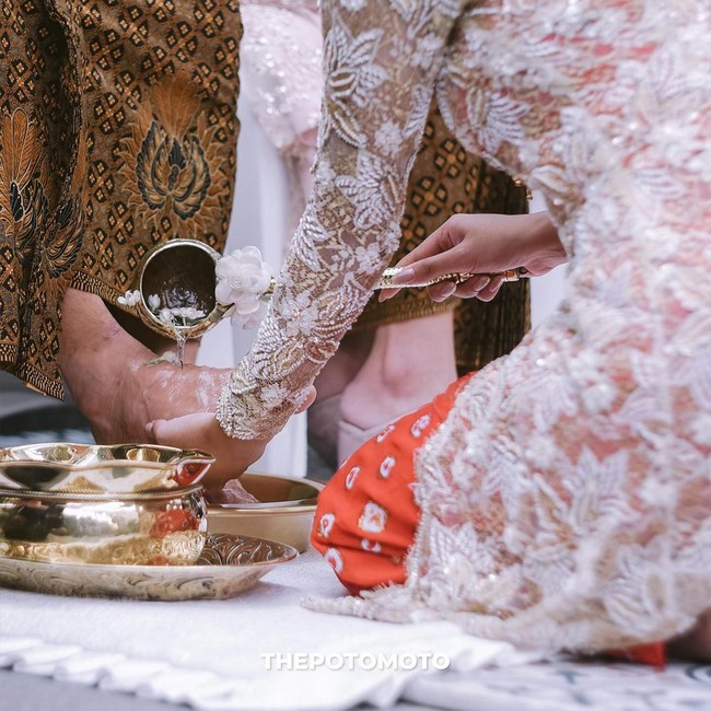 Aurel juga membasuh kaki kedua orang tuanya. Ini merupakan simbol permohonan doa restu anak kepada orangtua. (Foto: Dok. The Potomoto)