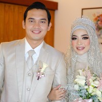 Saat resepsi pernikahan, Novia tampak memakai hijab chiffon babydoll yang dililit rapi ke belakang dan dilengkapi dengan inner hijab bahan kaus agar bagian rambut tidak terlihat. Gaya hijab ini akan mempercantik hiasan headpiece mahkota dan wedding veil.  Foto: Instagram: @luckyhakim9